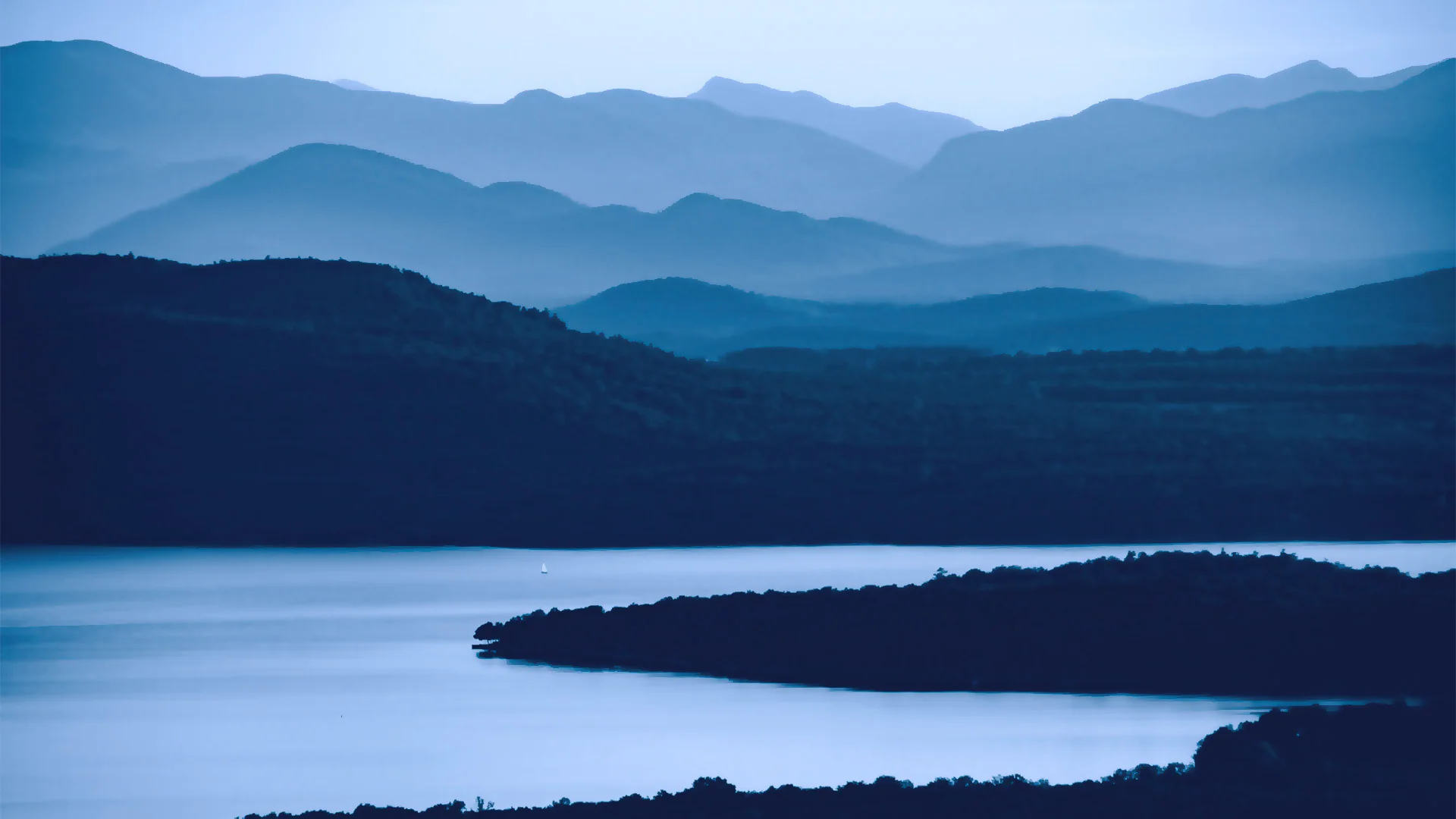 Layered mountain peaks beyond a lake